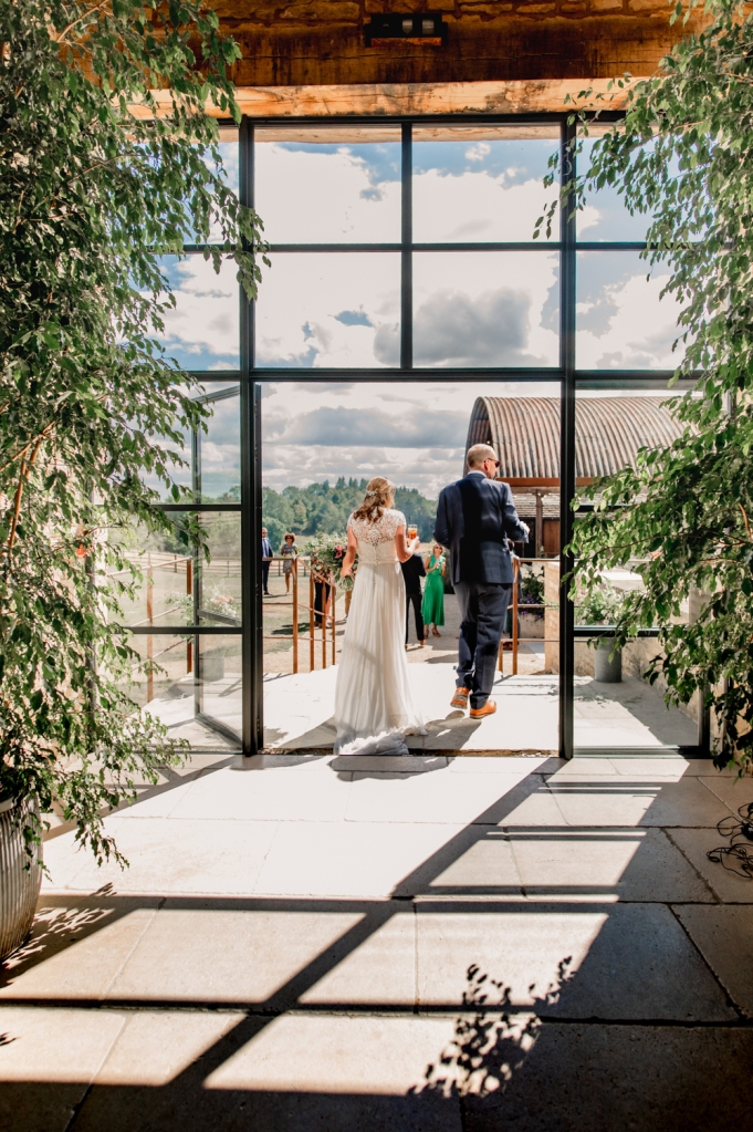 bride and groom going through glass doors old gore barn