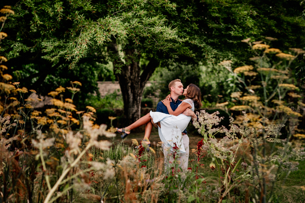 couple kissing in lush countryside cotswolds